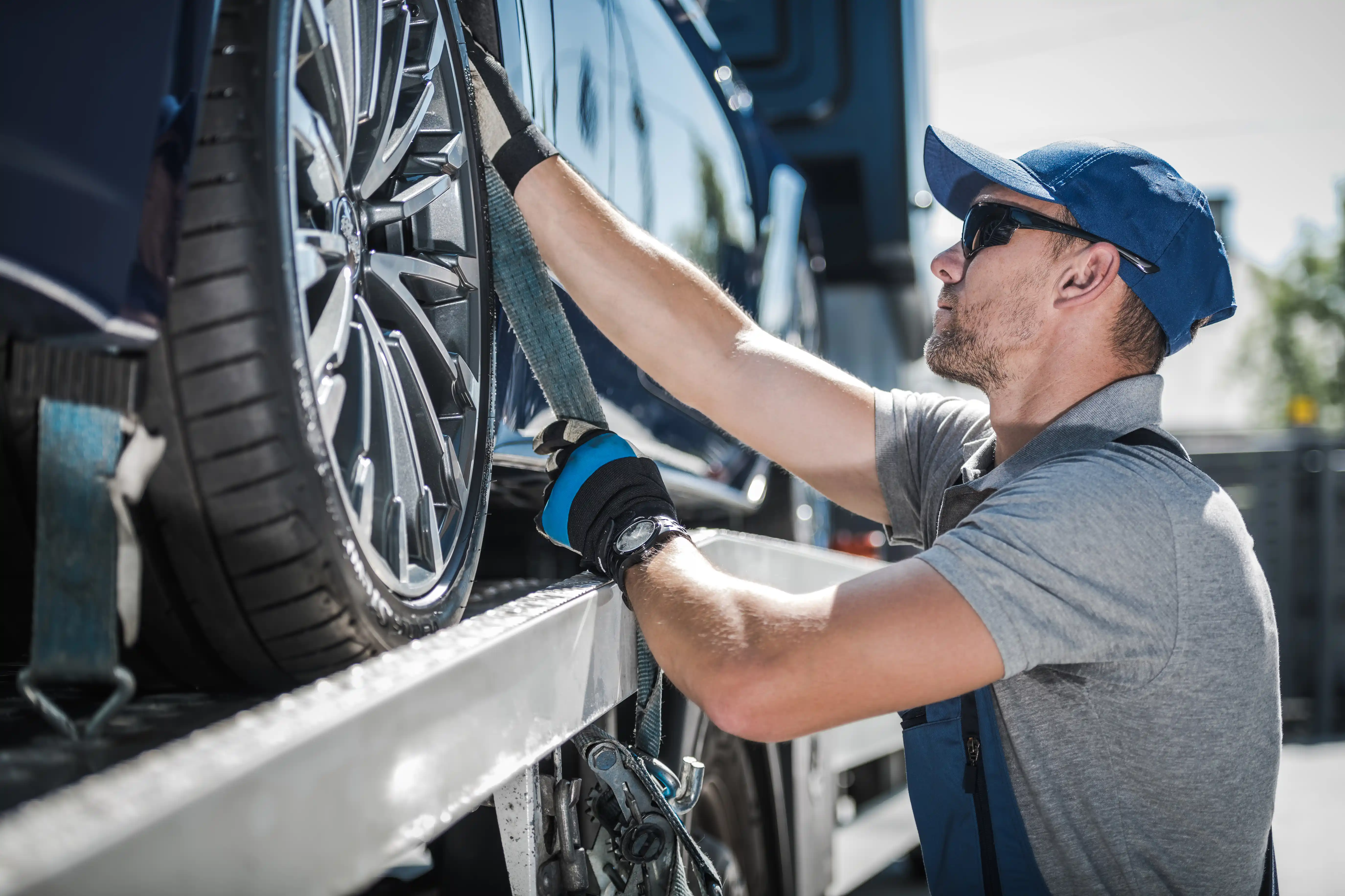 Auto hauler securing a vehicle on a carrier trailer